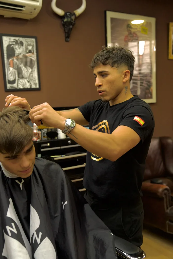 Alfredo peinando a un cliente